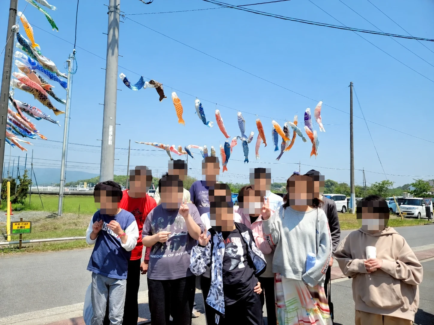 青空の下、こいのぼりを背景にした集合写真